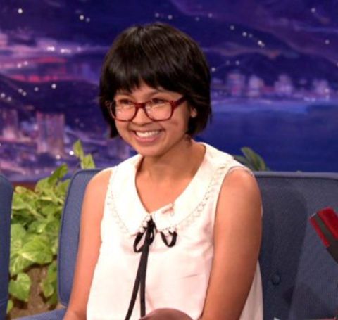 Charlyne Yi in a white top smiles at the audience. 