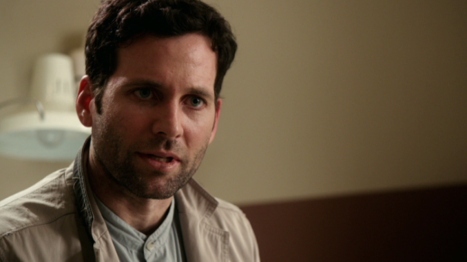 Eion Bailey caught on television acting wearing a grey coat.