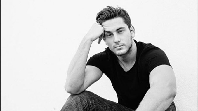Brent Antonello in black t-shirt and black jeans poses for a photoshoot.