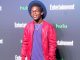 Camrus Johnson in a red jacket and blue t-shirt at a Hulu event.