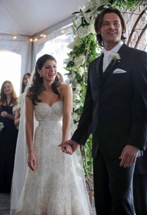 Genevieve Cortese holding the hand of her husband, Jared at their wedding.