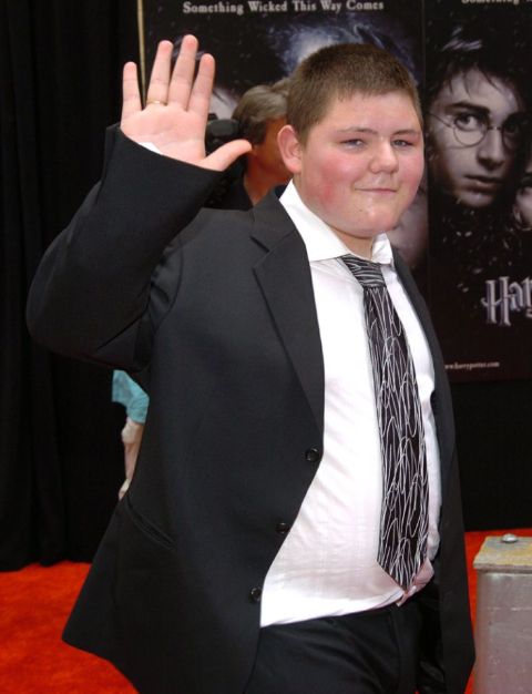 Jamie Waylett waving at camera while attending the red carpet of the film Harry Potter.