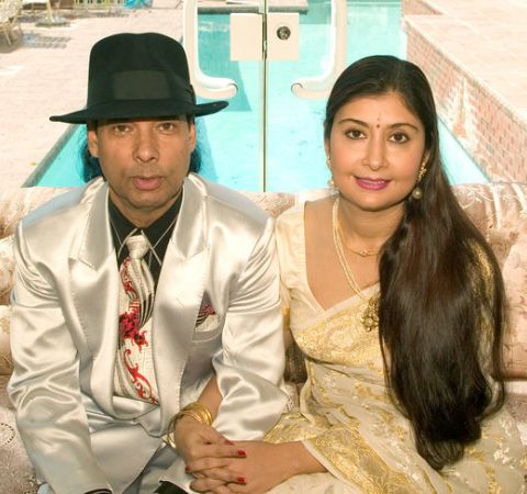 Bikram Choudhury in a silver suit with wife Rajashree Choudhury.