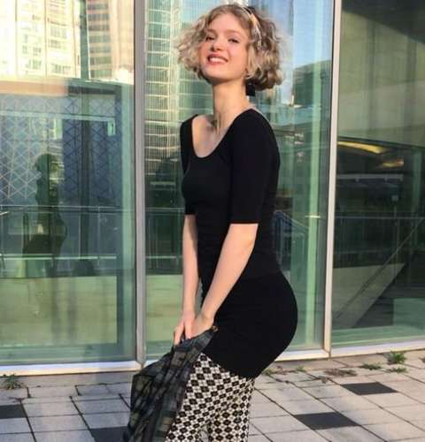 Elena Kampouris giving a pose in a black dress.