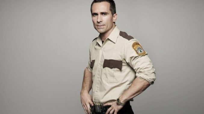 Nestor Carbonell in a police costume.