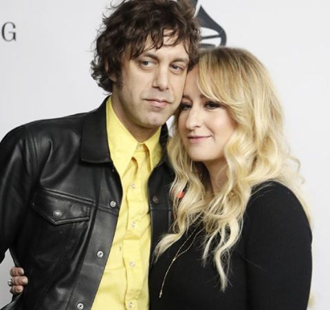 Jeremy Ivey in a black coat and yellow shirt with wife Margo Price. 