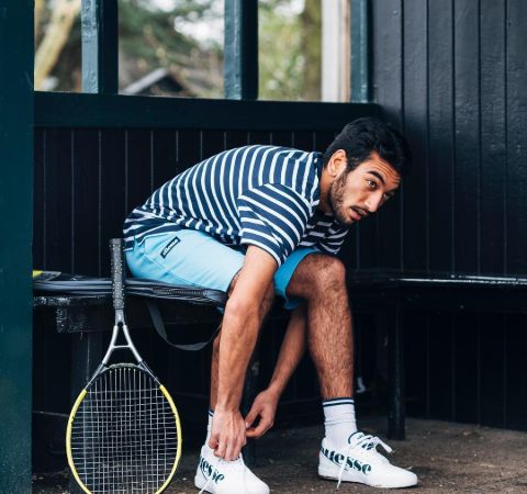 Nabhaan Rizwan tying his boots before a tennis match.