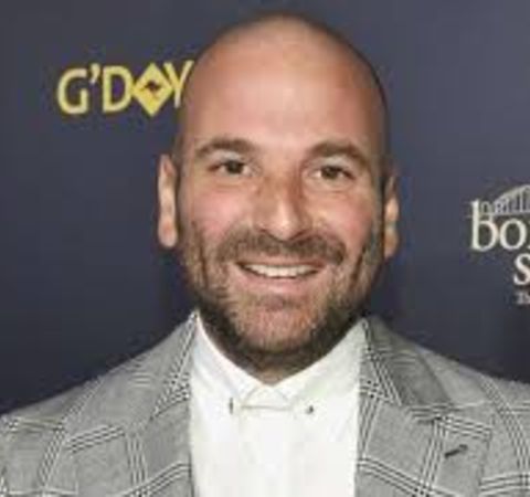 George Calombaris in a grey suit with white shit.