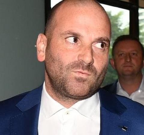George Calombaris in a blue suit with white shirt.