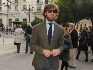 Rosauro Varo Rodriguez in a grey suit walks around the streets.