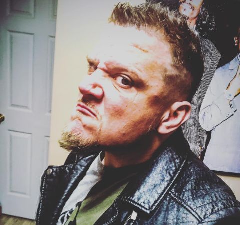 Sami Callihan in a black leather jacket poses for a selfie.