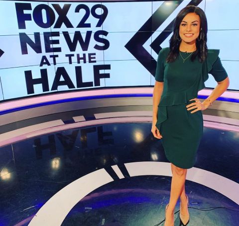 Shaina Humphries in a green dress poses at the sets of Fox 29 news.