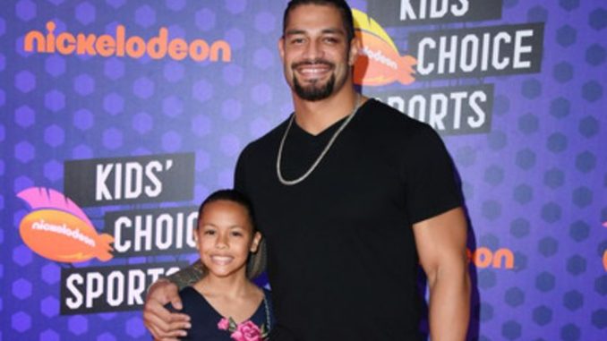 Joelle Anoa'i with her dad Roman Reigns in a black t-shirt.