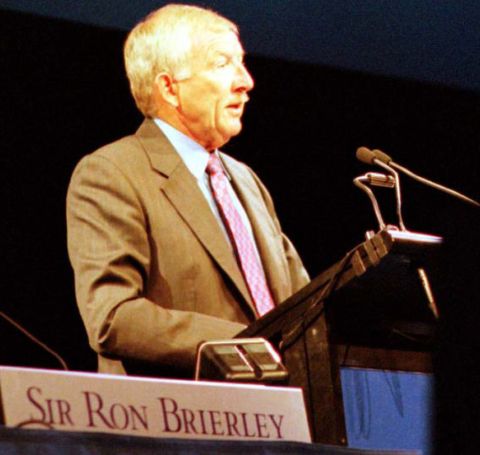 Sir Ron Brierley in a brown suit giving a speech.