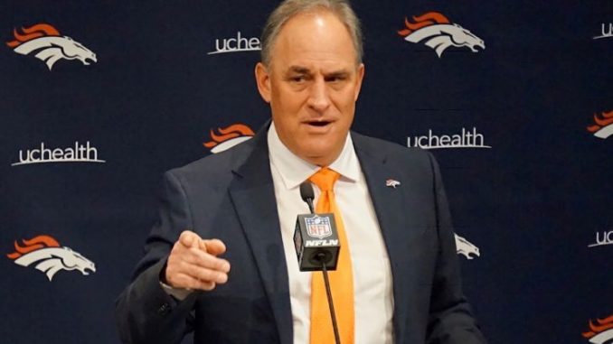 Vic Fangio in a black suit poses during an interview.