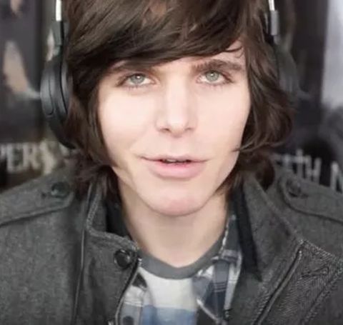Onision in a black coat poses for a photo.