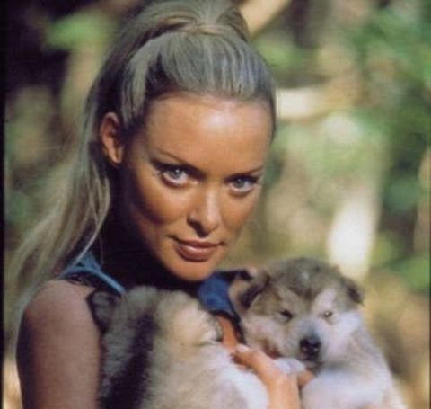 Actress Dylan Bierk poses with two puppies in the movie sets.