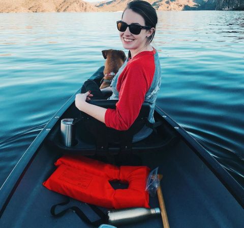 Laina Morris in a boat in red t-shirt alongside pet dog Gilly.
