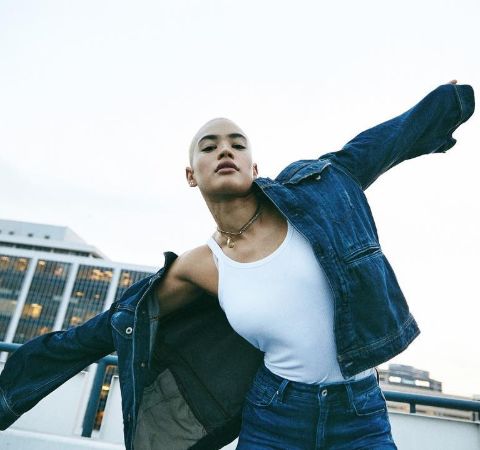 Mette Towley in a jeans jacket and white t-shirt poses for a photo.