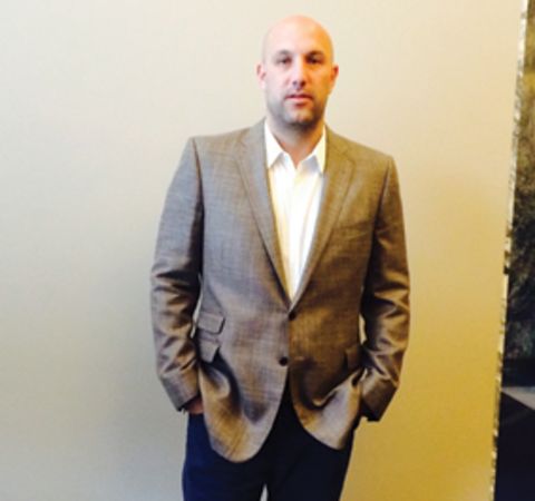 Rich Kleiman in a grey suit poses for a picture.