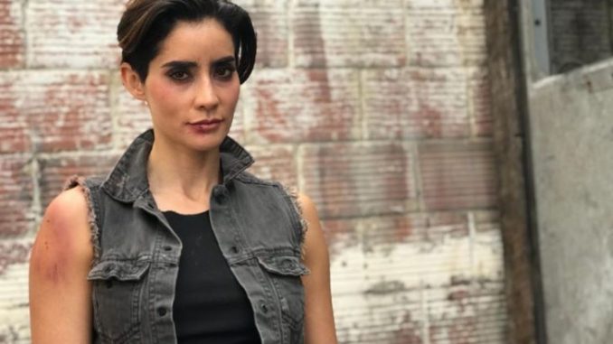 Paola Nunez in a black outfit poses during a photoshoot.