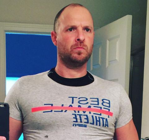 Ryen Russillo in a grey t-shirt poses for a picture.