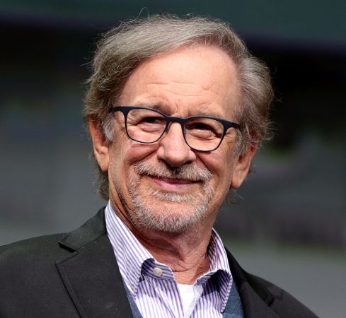 Steven Spielberg in a black suit poses for a picture