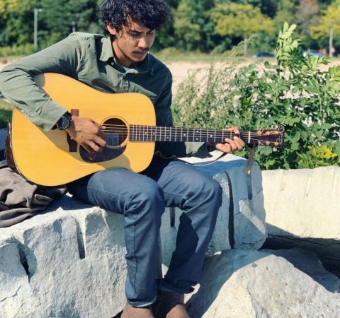 Singer Dibesh Pokharel holding his guitar.