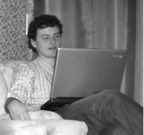 James Richman in a white shirt using a laptop.