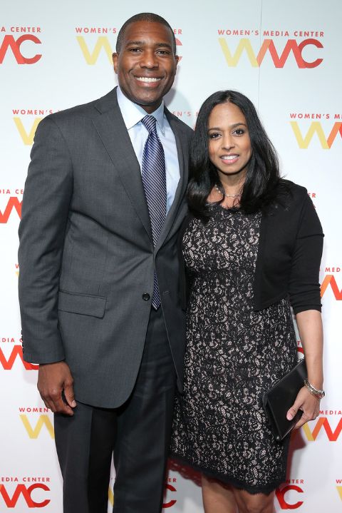 Tony West in a black suit poses a picture with Maya Harris.