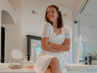 Klailea Bennett in a white dress poses a picture.