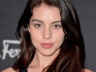 Adelaide Kane in a black top poses for a picture.