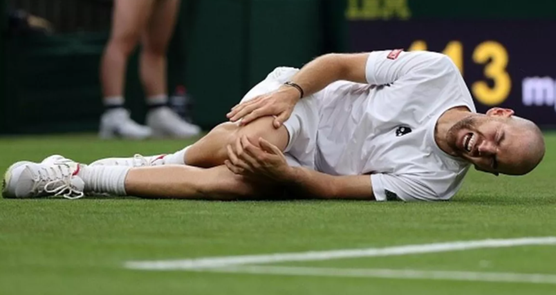 Adrian Mannarino slipped under the Centre Court roof and hurt his right knee playing against Roger Federer