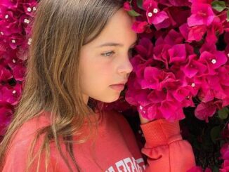 Ryan Kiera Armstrong posing with the flowers.